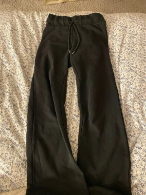 Svarta mjukisbyxor från H&M Divided - Svarta mjukisbyxor från H&M Divided med dragsko i midjan. Tillverkade i mjukt material med 79% bomull och 21% polyester. Klassisk basic-modell med normal passform och resår i midjan för extra komfort.