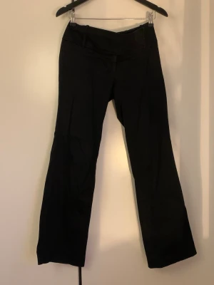 Svarta bootcut kostymbyxor Oasis - Svarta kostymbyxor med bootcut och bred linning.  De går att ha bälte och är  i ett mjukt tyg! Från Oasis! Och är lågmidjade!   