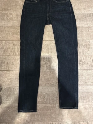 Mörkblå slim fit jeans från Dressmann - Snygga mörkblå jeans från Dressmann Premium Jeans med slim fit-passform. Jeansen är gjorda i slitstarkt denim och har en modern look som passar till sneakers eller boots. Dom är använda 1 gång, ordinarie pris är 800kr