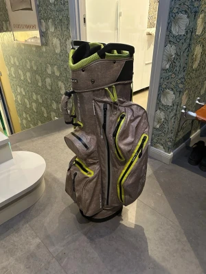 BIG MAX golfbag – perfekt för vagn! - Säljer en mycket praktisk BIG MAX golfbag med gott om utrymme. Massor av stora och små fack, inklusive ett cooler-fack som håller t.ex. vatten kallt på sommaren. ✔ Plats för 14 klubbor (och fler vid behov) ✔ Cart bag – gjord för vagn men kan även bäras med bärrem ✔ Helt regntät, regnskydd ingår  Ett fack har trasig dragkedja (se bild 4) men har aldrig använts. Liten reva på sida 5, påverkar inte funktionen alls. Nypris ca 3000 kr, säljes för 699kr! 📍Finns att hämta i Sigtuna!😄