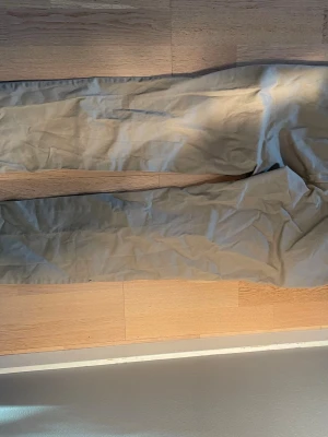 Beiga chinos från Uniqlo - Säljer ett par klassiska beiga chinos från Uniqlo i storlek 32x34. Byxorna är raka i modellen och har en mjuk känsla tack vare materialblandningen av bomull och elastan. Perfekta för en clean och avslappnad stil.