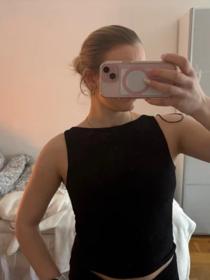 Svart blommig linnetopp Gina Tricot - Säljer en svart ärmlös linnetopp från Gina Tricot i storlek XS. Toppen har ett diskret blommigt mönster i tyget och en rak halsringning. Perfekt att styla med jeans eller kjol för en snygg look. Aldrig använd