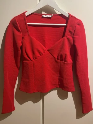 Röd långärmad topp från NA-KD - Säljer en ribbad röd topp från NA-KD i storlek S. Endast använd en gång, som att den skulle vara i nyskick💗