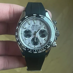 Seiko Mod Daytona-inspirerad – Unique Dial - ✨ Specifikationer Modell: Seiko Mod Daytona-inspirerad 🏁 Urverk: Automatiskt Seiko-urverk Boett: Rostfritt stål med tachymeter-bezel Storlek: 40 mm 📏 Glas: Reptåligt safirglas 💎 Urtavla: Unik specialdesign med kontrasterande subdials