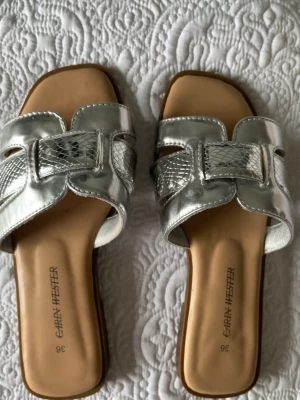 Silvriga sandaler  - Silver sandaler, superfina somriga och sköna att gå i. Använda några få gånger. Storlek 36 men passar mig som har 37!💗💗