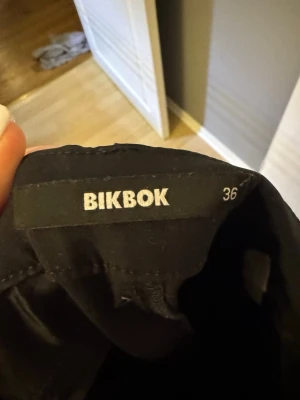 Svarta bootcut byxor från BikBok - Säljer ett par svarta byxor från BikBok i storlek 36. De har en klassisk bootcut-modell med utsvängda ben och midjehällor. Perfekta till sneakers eller boots och riktigt snygga till en enkel topp eller hoodie.