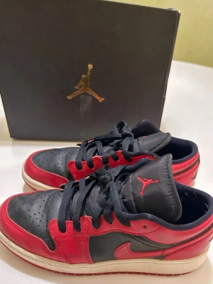 Air Jordan 1 Low röd - Jag säljer mina jordans low i storlek 38/39. Färgen är röd/svart och de kommer i orginalförpackning. De är använda men i bra skick. 