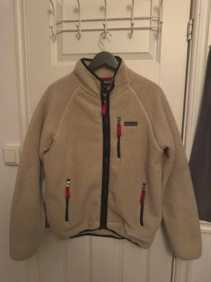 Beige Patagonia Fleece - En snygg, praktisk och lätt fleece från Patagonia i storlek M. Fleecen har vart använd ett fåtal gånger och är perfekt nu inför våren!⭐️⭐️  Vid frågor är det bara att skicka ett meddelande.
