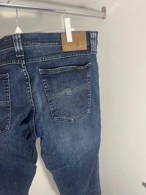 Mörkblå jeans från Nudie Jeans  - Mörkblå jeans från Nudie Jeans i strl  33,34 skulle däremot säga att de är mer åt 30,30 hållet. Jeansen har rak passform pris är diskuterbart.