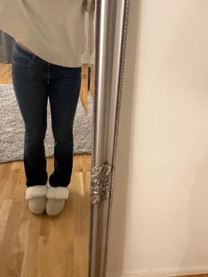 Mörkblå bootcut jeans från Zara - Säljer ett par mörkblå jeans från Zara med klassisk bootcut passform. Jeansen har normal midja, raka ben och är tillverkade i mjukt denimtyg. Perfekta till sneakers eller boots och riktigt snygga till en stickad tröja.