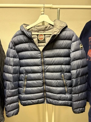 Blå pufferjacka från Colmar - Säljer en blå pufferjacka från Colmar med huva och två dragkedjeförsedda fickor. Perfekt för kyliga dagar och har en riktigt skön passform. Se bilder för lagning och en liten fläck, bara att höra av er vid frågor eller bud! Det är storlek 52 på jackan.