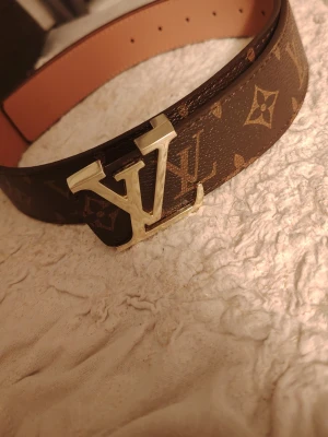 Brun L bälte  - Säljer en brun L bälte  som är 105cm lång och är oanvänd 