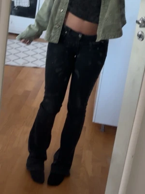 Svarta bootcut jeans låg midja - Säljer ett par svarta jeans med bootcut-modell och insyd låg midja. Jeansen är svarata men skulle säga att den kan se lite mörk gråa ut också. Byxorna har ett litet hål mellan bena men de syns ingenting alls och känns inte heller. Byxorna passar xs men passar lika bra på s