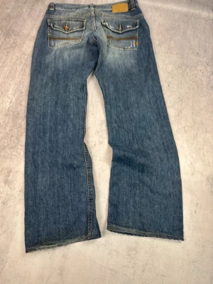 Blåa bootcut flare jeans - Säljer dessa swag jeans med sköning fade och passform. Längd:102cm, Midja tvärsöver:42cm, benöppning:24cm