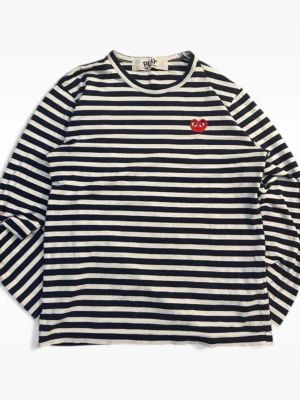 Comme des Garcons tröja - Säljer en klassisk långärmad topp från Comme des Garçons Play med marinblå och vita ränder. Toppen har ett rött hjärta med ögon broderat på bröstet och är gjord i mjuk bomull. Perfekt för en avslappnad men stilsäker look.
