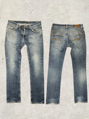 Nudie jeans – Tape Ted - Riktigt snygga Nudie jeans i modellen Tape Ted. Jeans i storlek W33 L32 med mått: midja 44 cm, längd 105 cm och benöppning 17 cm. Har snygga fades samt lagningar som gör jeansen ännu snyggare och ger dem en riktigt schysst, använd look. Perfekta för dig som gillar slim fit med karaktär. Vid fler funderingar är det bara att skriva mvh FABIANFASHION