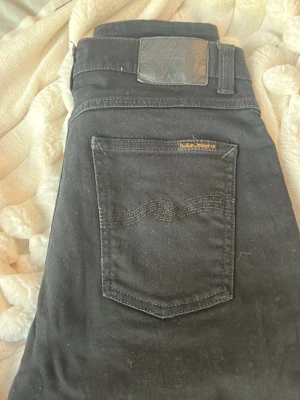Nudie Jeans Lean Dean - Ett par riktigt schyssta nudie jeans i modellen Lean Dean! De är i ett rätt bra skick men har tyvärr ett hål i den vänstra fickan (se bild) därav det mycket låga priset! Men är utöver detta ett riktigt fint plagg!👌Skriv om du är i behov av fler bilder på plagget eller om du har någon fundering!📸🖋️ Fraktar alltid dagen efter beställning om inte samma dag!📦