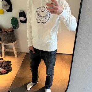 Maison Kitsuné hoodie - Stilren vit hoodie från Maison Kitsuné med ett schysst tryck på framsidan. Hoodien har en klassisk passform med långa ärmar och magficka. Mycket bra skick! Endast en minimal defekt (bild 5) som man överhuvudtaget inte ser om man inte kollar väldigt noga. 