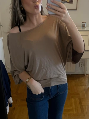 Beige offshoulder topp i bomull - Säljer en beige offshoulder topp med lös passform och trekvartsärm. 
