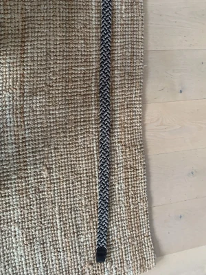 Flätat bälte från Jack & Jones - Snyggt flätat bälte från Jack & Jones i svart, beige och grått. Bältet har detaljer i mörkbrunt skinn och ett klassiskt spänne i silverfärg. Perfekt accessoar för att lyfta din outfit med en stilren touch.