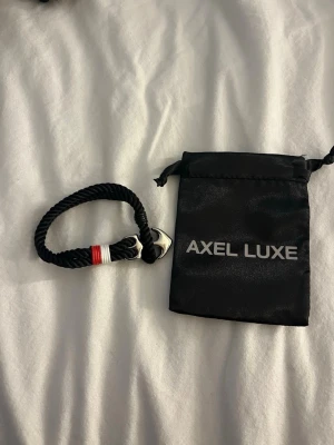 Svart reparmband Axel Luxe - Snyggt svart armband från Axel Luxe . Aldrig använt och levereras med den svarta påsen 