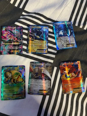 Samling Pokémonkort holo och GX/EX - Stor samling Pokémonkort med flera holo, GX och EX-kort. Blandade färger och motiv med populära Pokémon som Mega Mewtwo och Thundurus och fler. Alla kort är officiella och har glansig yta. Perfekt för samlare eller Pokémonfans. Hör av er om vad ni vill ha så skriver jag ett pris då pågrund av prisskillnaderna på de olika korten