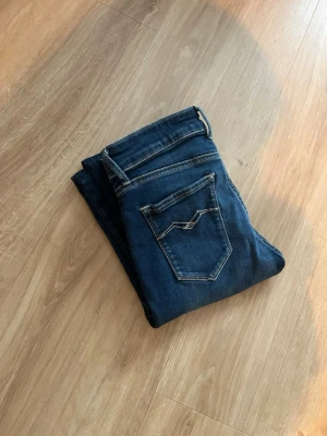 Mörkblå skinny jeans Replay  - Säljer ett par mörkblå skinny jeans med snygga kontrastsömmar och två bakfickor med dekorativa detaljer. Jeansen har klassisk femficksdesign och är tillverkade i stretchigt denimtyg för en bekväm passform.