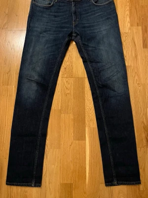 Acne Studio Jeans - (W36/L34) Säljer ett par mörkblå jeans från Acne Studio med rak passform och klassisk femficksdesign.  Materialet är denim i bomull och de har en läderpatch bak i midjan där det står ”Acne Studios”. Perfekta för en avslappnad och stilren look.