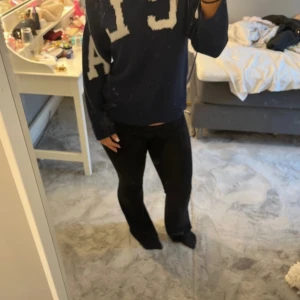 Mörkblå tröja med vita bokstäver - Säljer en mörkblå tröja med stora vita bokstäver på framsidan. Tröjan har långa ärmar och en avslappnad passform, perfekt för en casual look. Den är gjord i ett mjukt material som känns skönt mot huden.