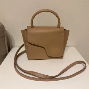 beige atp mini montalcino väska  - mini montalcino atp väska i beige färg den är lite ljusare i verkligheten, tror det är färgen hazelnut. nypriset är 3900kr mitt pris är 1200kr men går att förhandla! väskan är använd men fortfarande i bra skick kan skicka fler bilder 