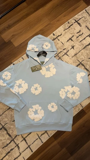 Ljusblå hoodie från Denim Tears - Säljer en ljusblå hoodie från Denim Tears, tröjan är som ny och passar både killar och tjejer, varm och skön speciellt för vintern.❄️