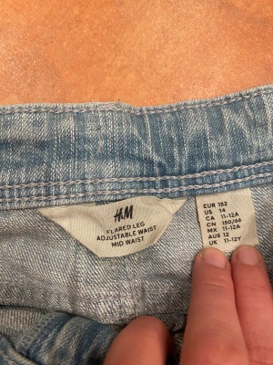 Bootcut ljusblå jeans - Snygga ljusblå bootcut jeans med klassisk femficksdesign och två bakfickor med lock och knapp. 