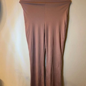 Rosa ribbade leggings med hög midja - Säljer ett par mjuka och stretchiga byxor i gamelrosa färg med ribbad struktur. Perfekta för en chill och avslappnad stil. Passar dig som gillar bekväma och trendiga byxor. Från lager 157 strl S. 