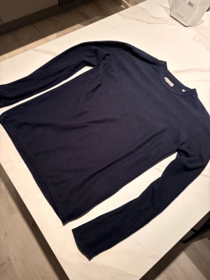 Mörkblå stickad tröja Jack & Jones - Rensar garderoben. Säljer en mörkblå stickad tröja från Jack & Jones i storlek S. Tröjan har rund hals och långa ärmar, perfekt för dig som gillar enkel och stilren design. Materialet är mjukt och skönt, passar dig som vill ha en klassisk look. Jag är 180 cm lång och den är liite för lång i ärmarna, så rekommenderar att köpa om man är 180 cm och uppåt