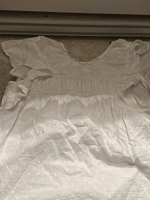 Vit blus med spets och prickar - Supersöt vit blus, en liten del av ärmen har rivits upp men inget som syns på insidan utan just den ärmen blir bara pyttelite större och ”öppnare” men går säkert att sy igen. Skulle säga att den är ganska puffig och luftig men skönt material 