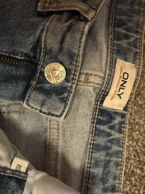Low waist  jeans från ONLY i ljusblå denim - Säljer ett par ljusblå jeans från ONLY med breda ben och klassisk femficksdesign. Jeansen har normal passform, dragkedja och knapp framtill. Materialet är jeans i bomull och de har en snygg vintage tvätt som ger en chill vibe.