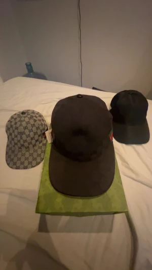 Svart GG keps med grönt och rött band - Säljer en svart GG keps med klassiskt grönt och rött band på sidan. Kepsen har justerbar rem i skinn baktill och är tillverkad i polyester. Snygg och stilren design med diskret GG -logga. Perfekt för dig som vill ha en exklusiv accessoar.