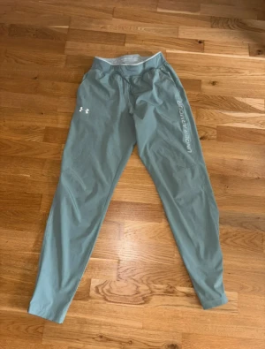 Under Armour träningsbyxor - Under Armour träningsbyxor – herr Säljer ett par snygga och bekväma träningsbyxor från Under Armour i en stilren ljusgrön/grå nyans.