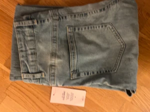 Ljusblå jeans från Nelly NYA med prislapp - Snygga ljusblå jeans från Isolde med raka ben och hög midja. Jeansen har fyra silverfärgade knappar framtill, klassiska fickor och bälteshällor. Materialet är mjukt denim och passformen är normal. Perfekt för dig som gillar en clean och stilren look.