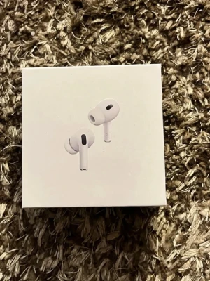 AirPods Pro - Snygga och populära Apple AirPods Pro i originalförpackning. Trådlösa hörlurar med aktiv brusreducering och hög ljudkvalitet. Förpackningen ser ut att vara i gott skick, perfekt för dig som vill ha premiumljud och smidig anslutning till Apple-enheter.