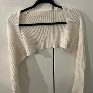 Vit croppad ribbad kofta från SHEIN - Säljer en vit croppad kofta från SHEIN i storlek XS. Den är ny men fick en fläck har inte testat få bort med vanish men går säkert att få bort. Koftan är ny annars😚