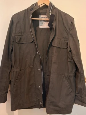 Militärgrön jacka Zadig & Voltaire - Parkajacka i militärgrön färg från Zadig & Voltaire med coolt broderat döskallemärke på ärmen. Liten fläck men går säkert bort i tvätten