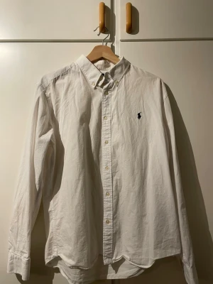 Vit skjorta från Polo Ralph Lauren - Säljer en blårutig skjorta från Ralph Lauren i storlek L (skulle mer säga att passformen på den är M). Skjortan är köpt här på Plick och jag har bara använt den ett par gånger. Perfekt för dig som gillar stilrena och tidlösa plagg. Skick: 9/10