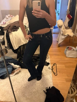 Mörkblå bootcut jeans från 157 - Snygga mörkblå jeans från 157 med bootcut-snitt och låg midja. Materialet är jeans med en skön passform som sitter snyggt över höfterna och låren. 