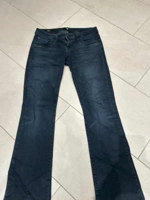 Mörkblå bootcut jeans från LTB - Snygga mörkblå jeans från LTB i modell valerie, nypris 830 kr. Jeansen har en normal passform och är tillverkade i mjukt denimtyg. Säljes på grund av att de inte längre passar. Är även för långa på mig som 158, därav slitning vid hälarna. Storlek 27 x 30