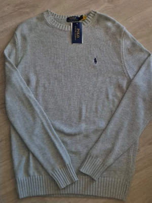Ralph Lauren tröja - Fin stickad tröja från Ralph Lauren i färgen grå, helt ny! Storlek S men passar även M. Hör av er vid frågor eller funderingar! 