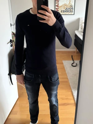 Mörkblå merinoullströja från J.Lindeberg - Snygg mörkblå  tröja från J.Lindeberg i storlek S. Tröjan är i bra skick men har lite små slitningar på armbågarna men inget som är så synligt. Hör av er vid funderingar