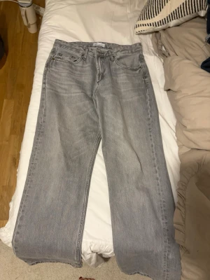 Grå wide jeans från Zara - Säljer ett par gråa jeans från Zara med breda ben och klassisk femficksdesign. Jeansen har en ljusgrå tvätt och raka sömmar, vilket ger en chill och modern vibe. Perfekt för dig som gillar loose fit och vill ha en avslappnad stil.