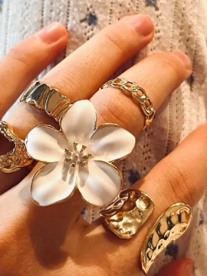 5st snygga ringar - Bilderna visar flera ringar i guldton, bland annat en stor ring med vit blomma och andra med organiska former. Ingen väst syns på bilderna. Går att köpa separat om man häller vill det (antingen en eller fler såklart) Finns redan en annons eftersom jag ville förnya men inte ta bort de. gammal 