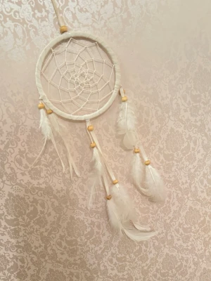 Vit Drömfångare  - En drömfångare med vita fjädrar och träpärlor, men ingen väst finns med.